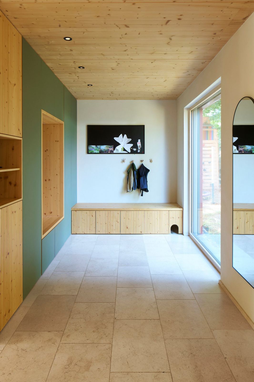 Garderobe aus Holz, grüne Schrankfront, Natursteinboden